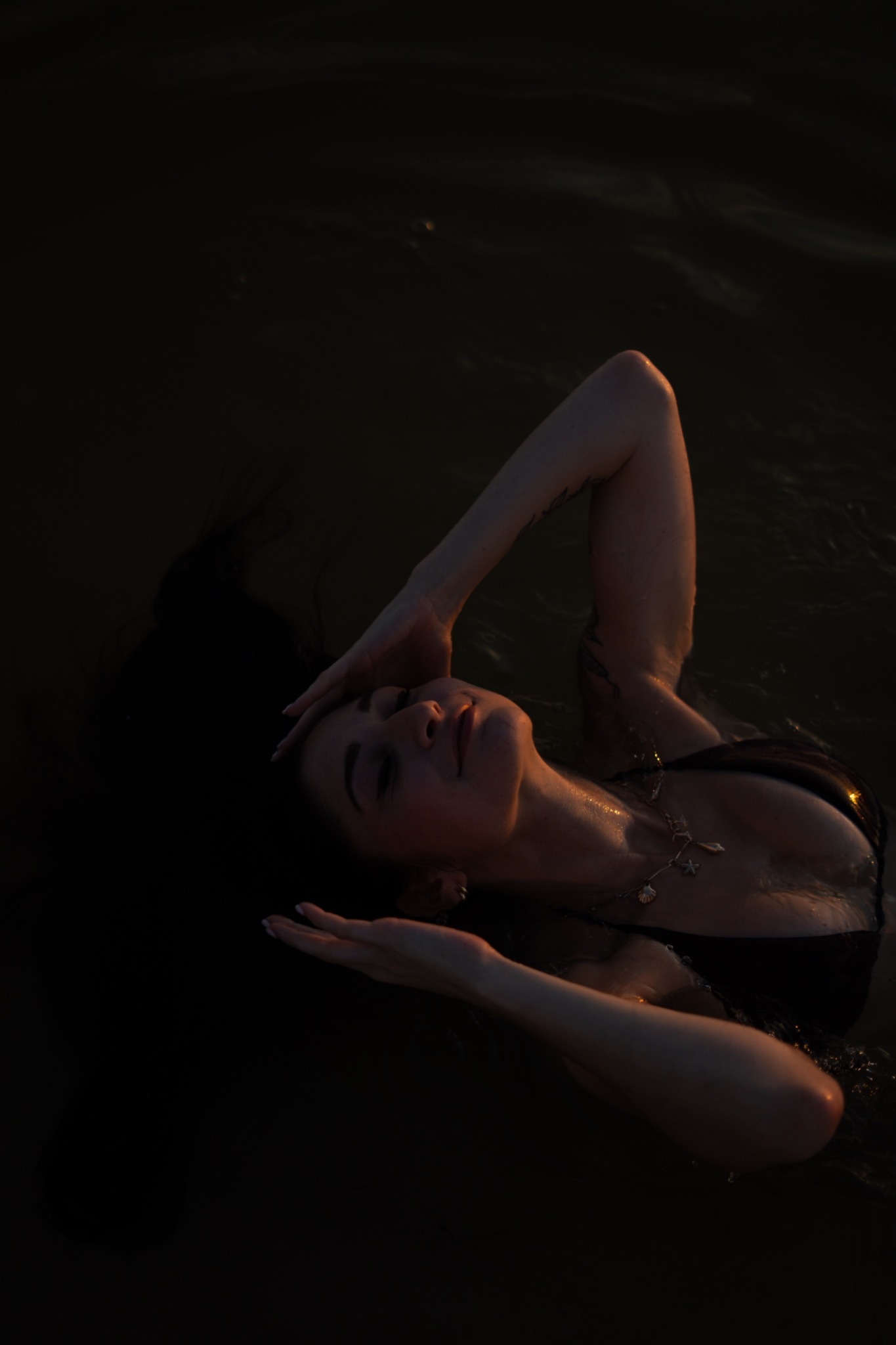 Lindy floating in the water with her arm above her head