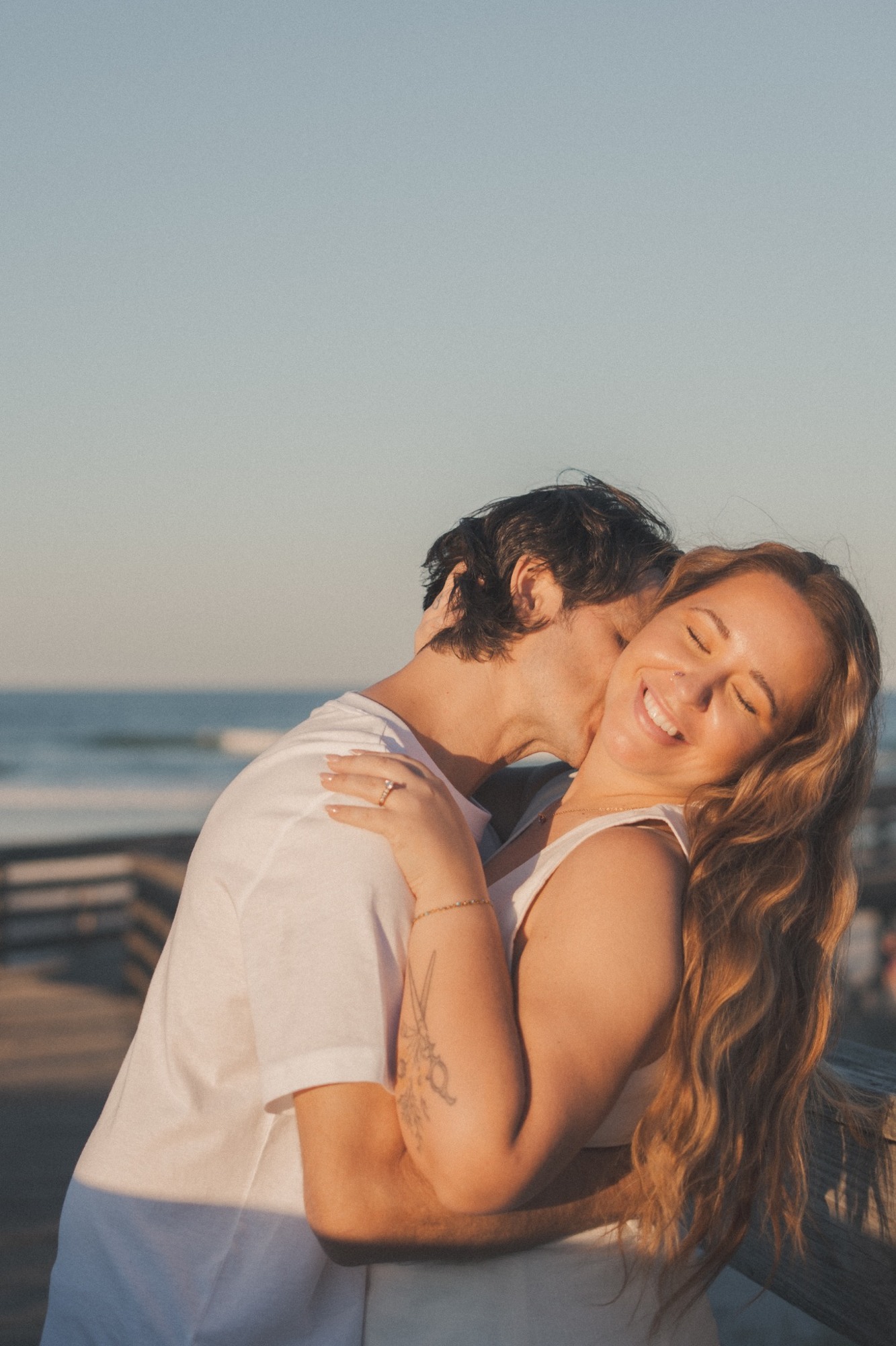 A joyful close embrace on a coastal boardwalk
