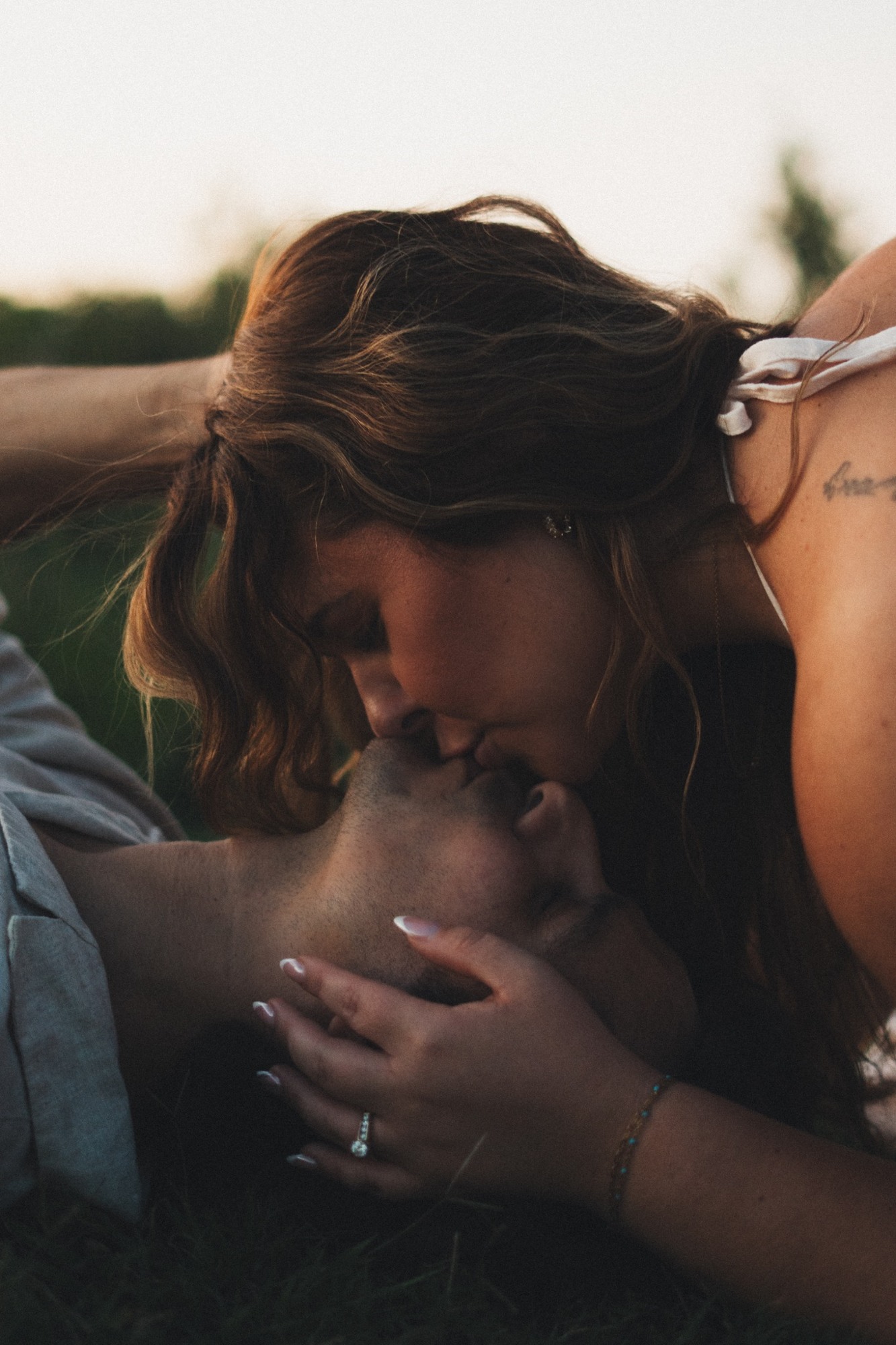 A couple sharing an intimate kiss at sunset