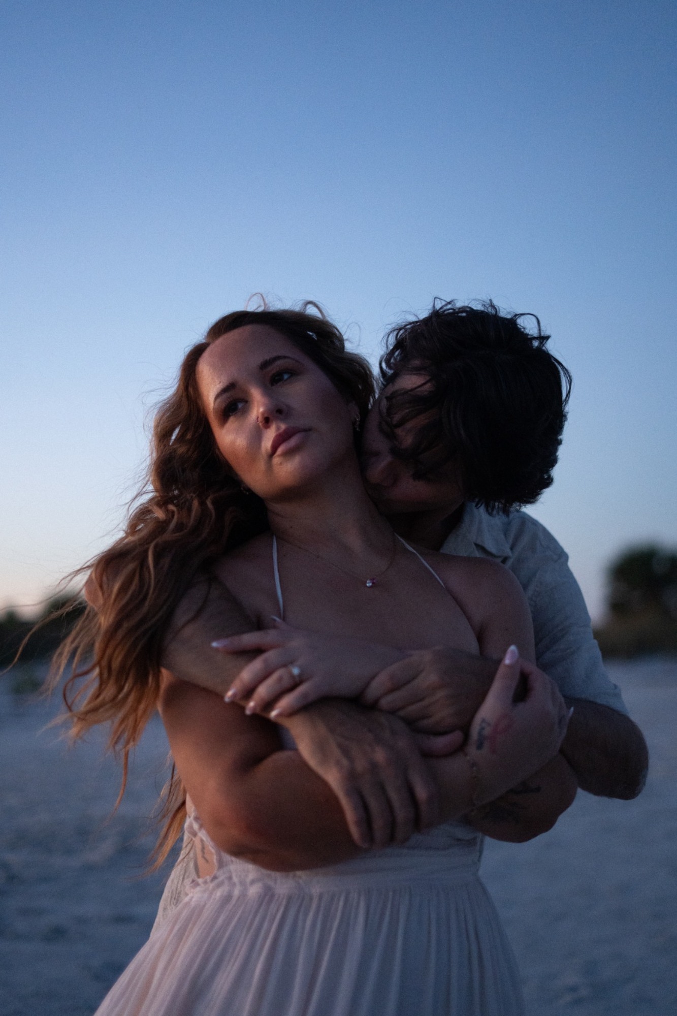 A couple sharing a close embrace at blue hour on the beach
